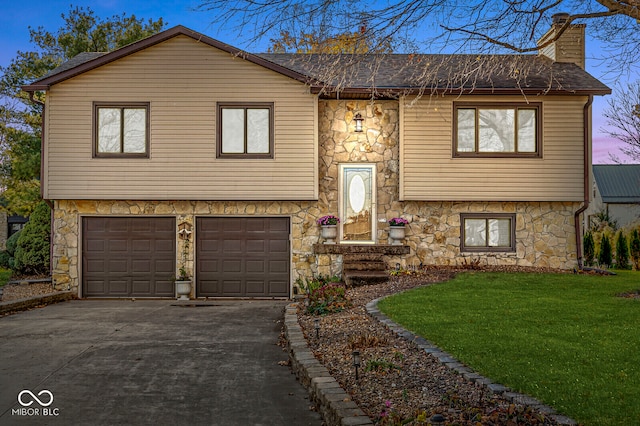 raised ranch with a yard and a garage