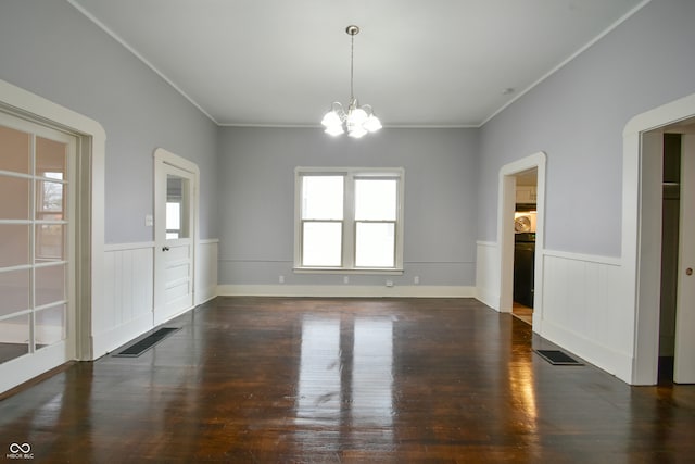 unfurnished dining area featuring crown molding, dark wood-type flooring, and an inviting chandelier