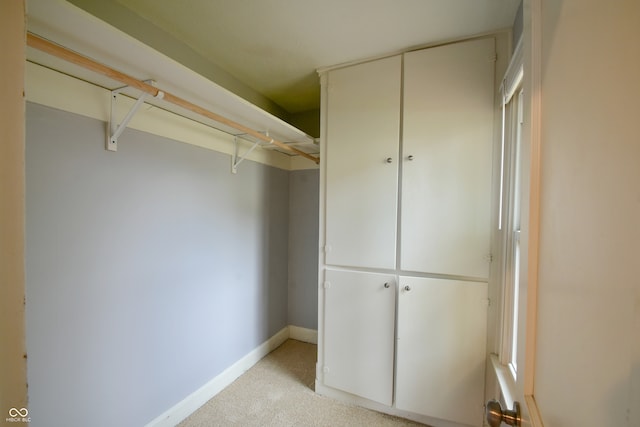 walk in closet featuring light carpet