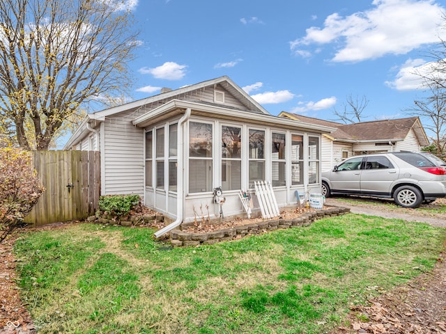 view of side of property with a lawn and a sunroom