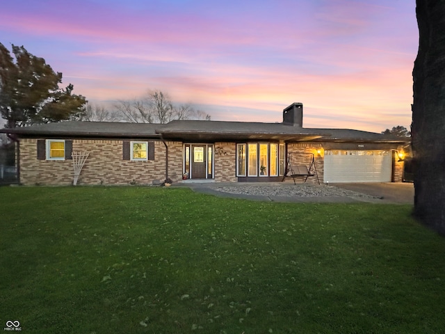 back house at dusk with a garage and a yard