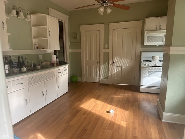 kitchen featuring ceiling fan, sink, light hardwood / wood-style floors, white appliances, and white cabinets