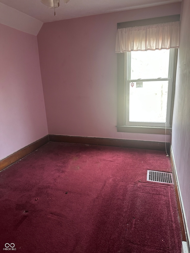 carpeted empty room featuring ceiling fan and lofted ceiling