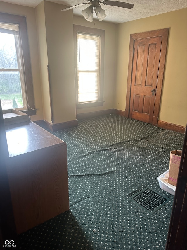 unfurnished bedroom featuring ceiling fan, carpet, and a textured ceiling