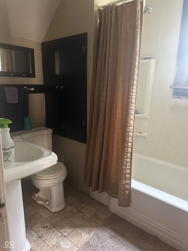 bathroom with toilet, vaulted ceiling, shower / tub combo with curtain, and tile patterned flooring