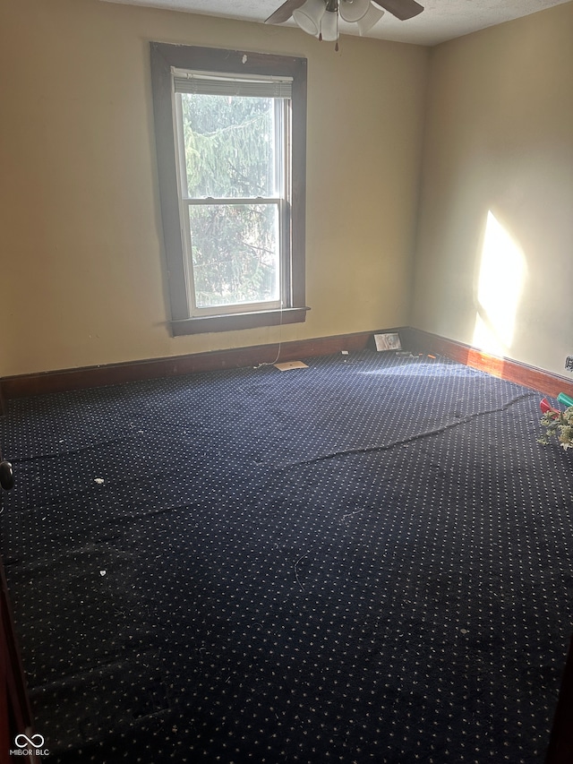 carpeted empty room featuring ceiling fan