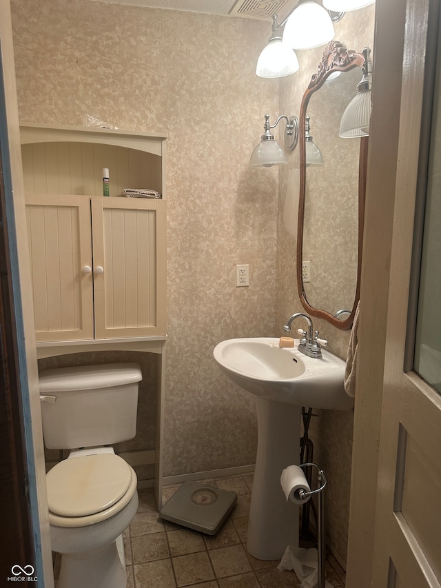 bathroom with toilet and tile patterned floors