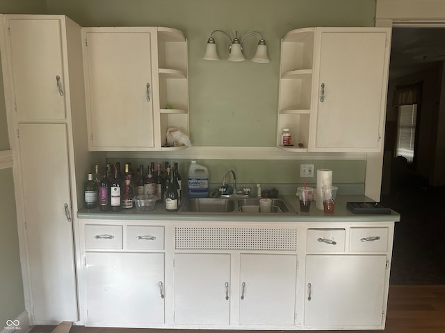 bar featuring white cabinetry, sink, and hardwood / wood-style flooring