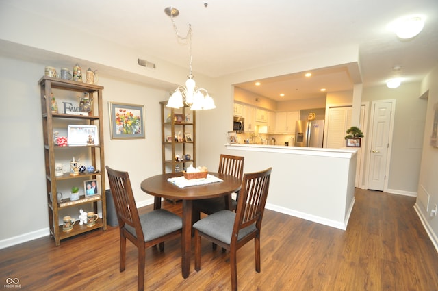 dining area featuring dark hardwood / wood-style floors and an inviting chandelier