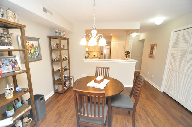 dining area with dark hardwood / wood-style floors and an inviting chandelier