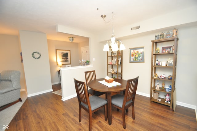 dining area featuring dark wood-type flooring and a chandelier