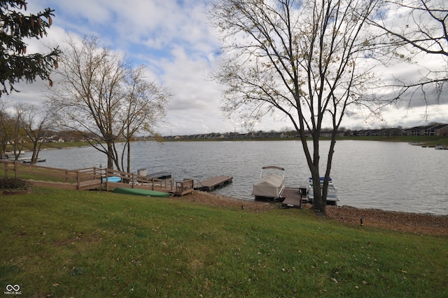 dock area featuring a lawn and a water view