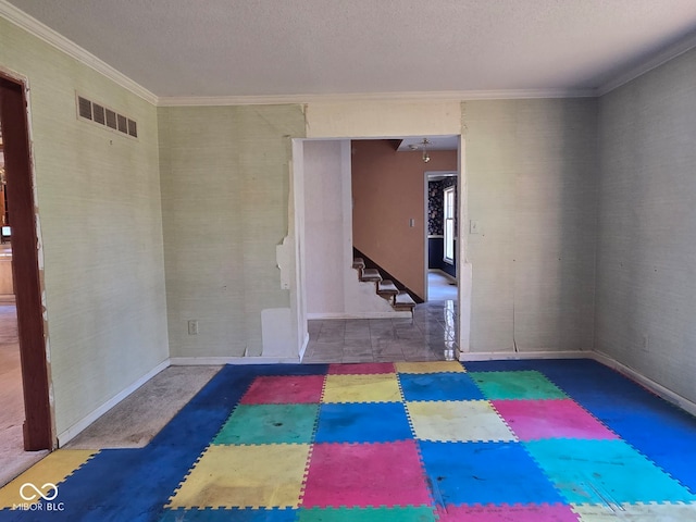 empty room featuring a textured ceiling and crown molding