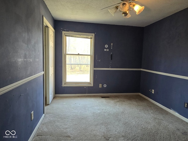 unfurnished room with light carpet, a textured ceiling, and ceiling fan