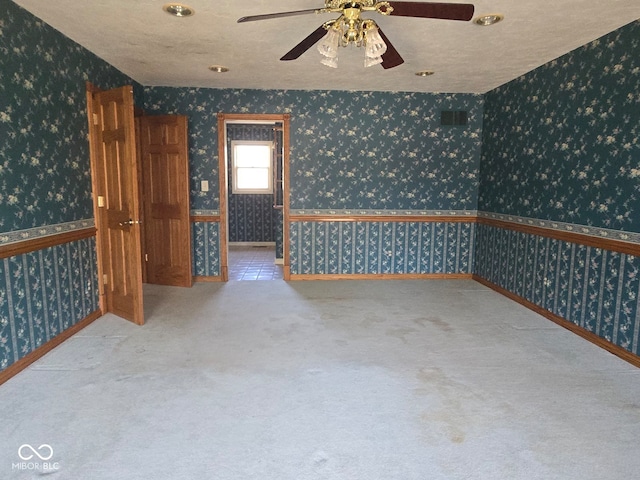 carpeted spare room with ceiling fan and a textured ceiling