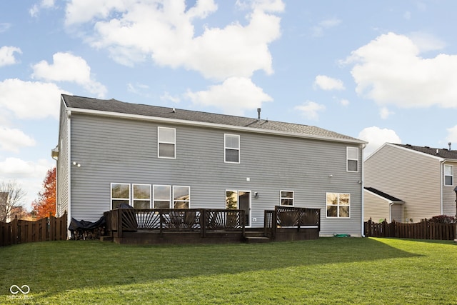 back of property featuring a wooden deck and a yard