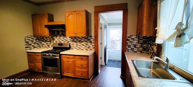 kitchen with backsplash, dark wood-type flooring, sink, gas stove, and extractor fan