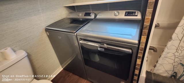 laundry room with washing machine and dryer and dark wood-type flooring