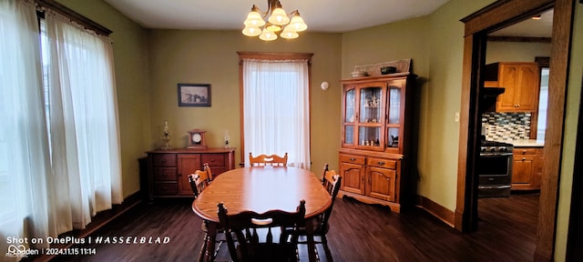 dining area featuring a wealth of natural light, dark wood-type flooring, and an inviting chandelier