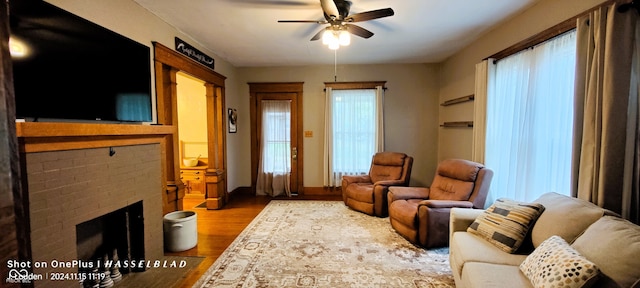 sitting room featuring hardwood / wood-style flooring, ceiling fan, a fireplace, and a wealth of natural light