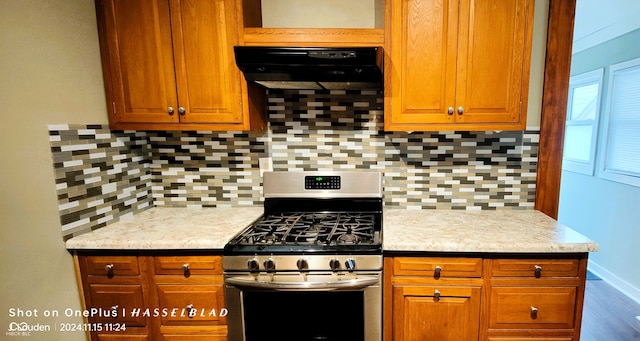 kitchen with gas stove, decorative backsplash, and extractor fan