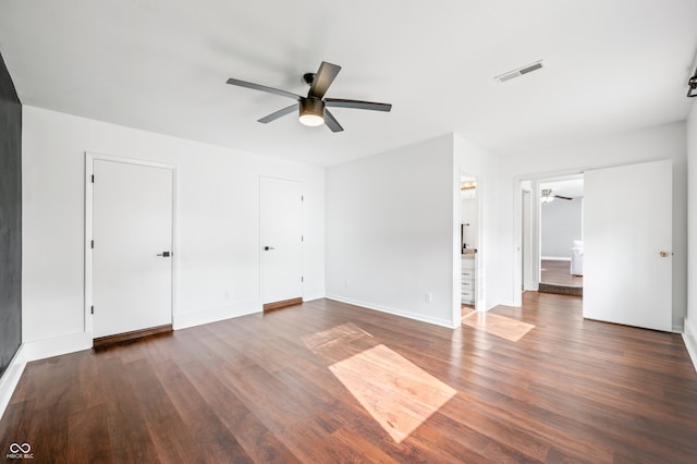 unfurnished bedroom with ensuite bathroom, dark hardwood / wood-style flooring, and ceiling fan