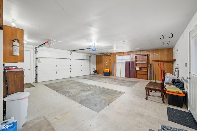 garage featuring wood walls and a garage door opener