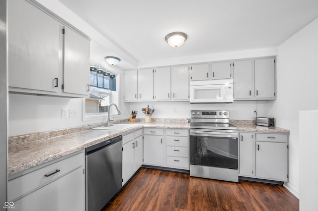 kitchen with white cabinets, sink, stainless steel appliances, and dark wood-type flooring