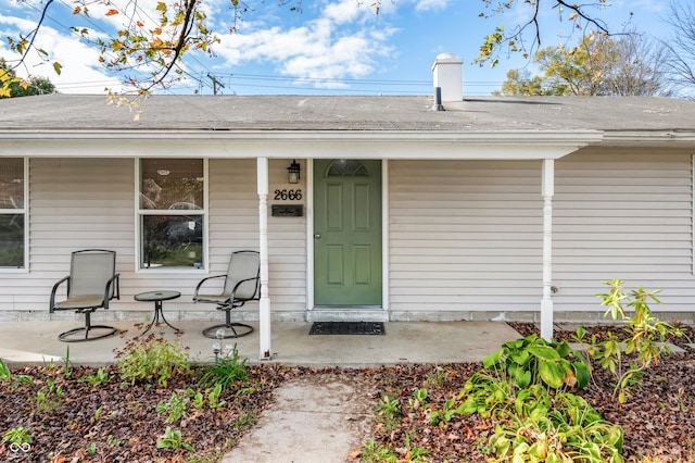 view of exterior entry featuring covered porch