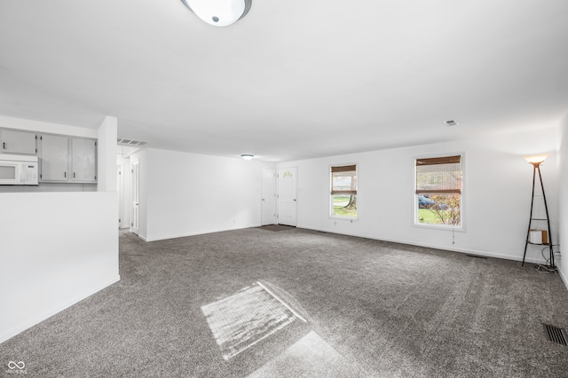 unfurnished living room with dark colored carpet