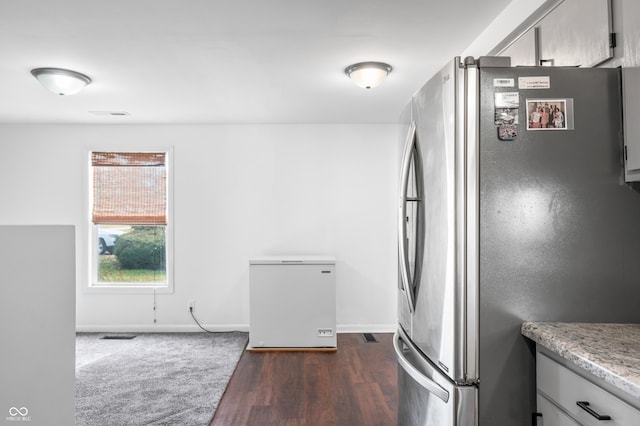 kitchen with stainless steel fridge, refrigerator, and dark hardwood / wood-style flooring