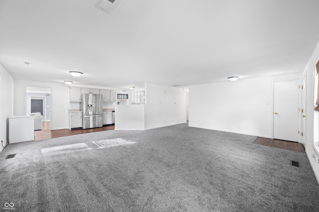 unfurnished living room featuring dark carpet