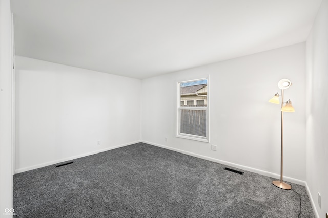 unfurnished room featuring dark colored carpet