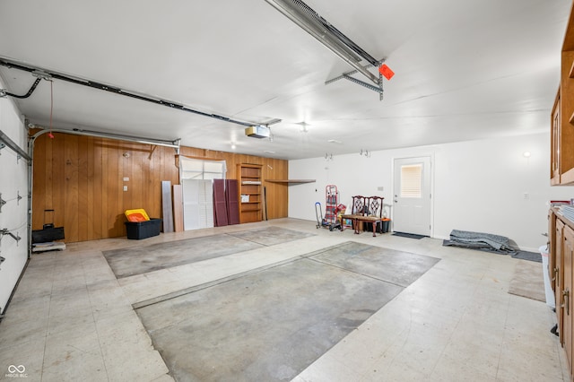 garage featuring a garage door opener and wood walls