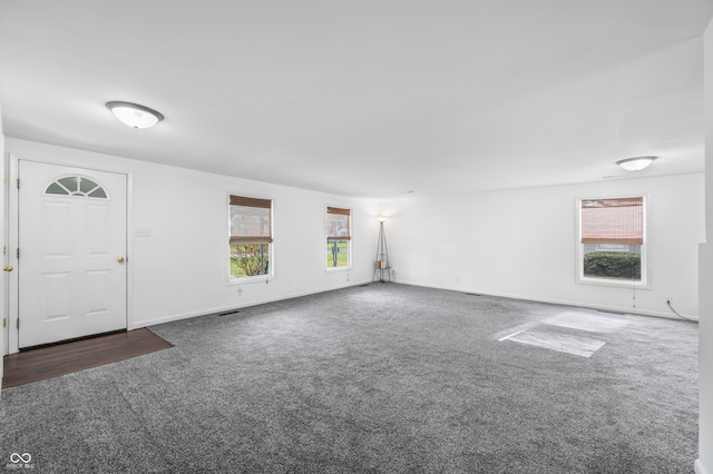 interior space with dark carpet and plenty of natural light