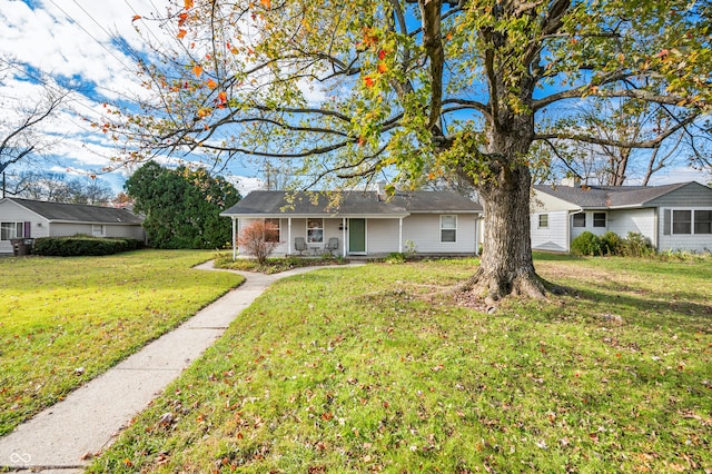 ranch-style home featuring covered porch and a front yard