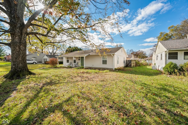 back of property with cooling unit and a lawn