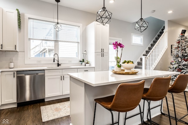 kitchen featuring dishwasher, decorative light fixtures, a kitchen island, and a healthy amount of sunlight