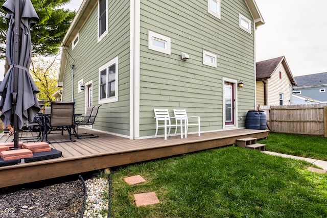 rear view of property featuring a yard and a deck