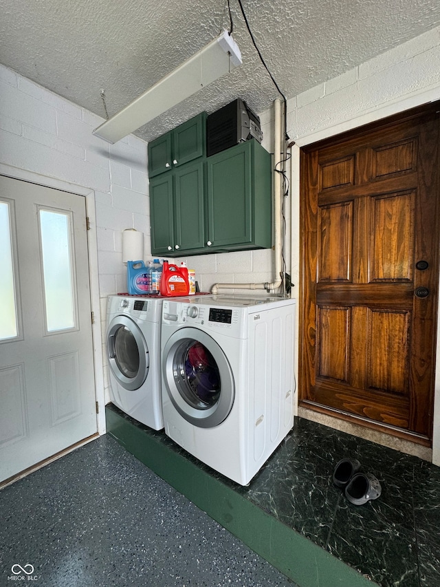 laundry room featuring cabinets, washing machine and dryer, and a textured ceiling