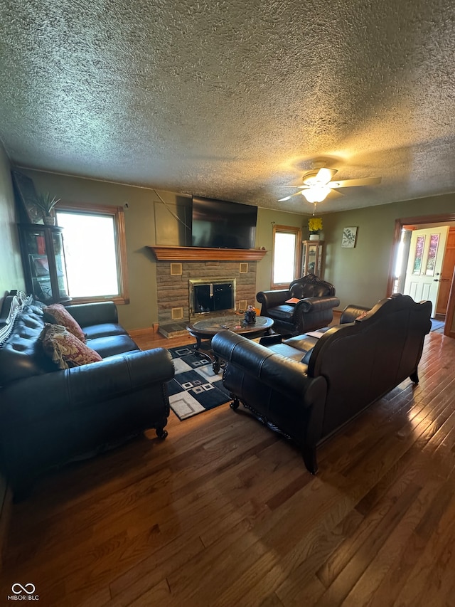 living room with a fireplace, wood-type flooring, and a textured ceiling