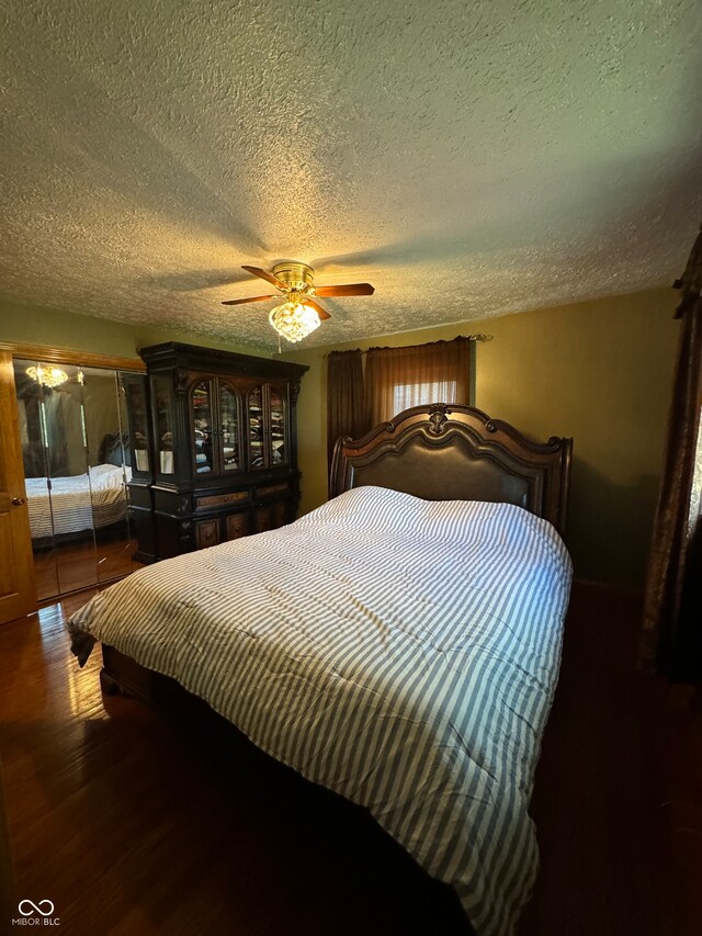 bedroom with hardwood / wood-style floors, a textured ceiling, and ceiling fan