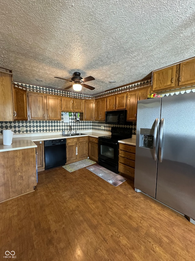 kitchen with black appliances, decorative backsplash, ceiling fan, and hardwood / wood-style floors