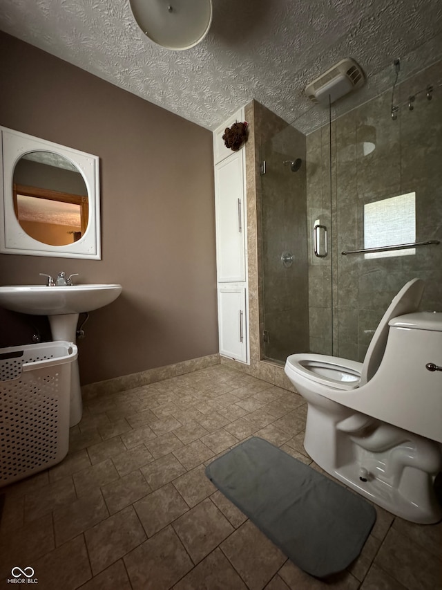 bathroom featuring tile patterned flooring, an enclosed shower, a textured ceiling, and toilet