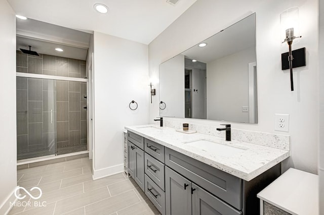 bathroom with vanity and a shower with door