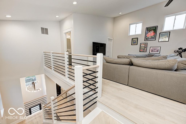 living room with light hardwood / wood-style floors and high vaulted ceiling