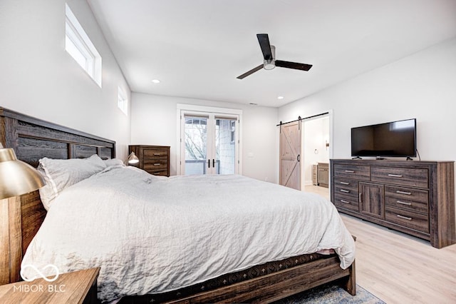 bedroom featuring access to exterior, light wood-type flooring, ensuite bath, ceiling fan, and a barn door