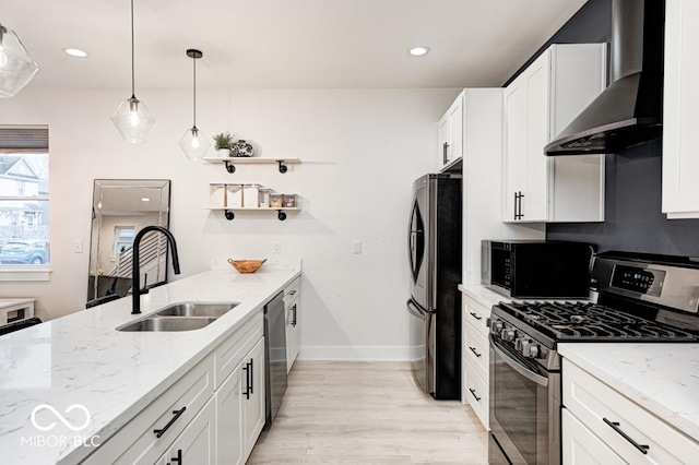 kitchen with wall chimney exhaust hood, stainless steel appliances, sink, white cabinets, and light hardwood / wood-style floors