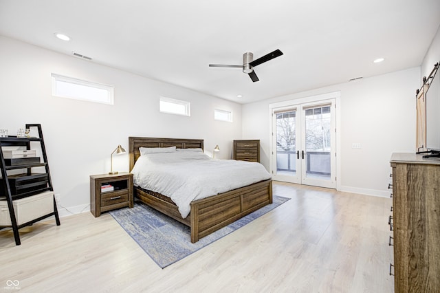 bedroom with access to outside, french doors, ceiling fan, a barn door, and light hardwood / wood-style floors