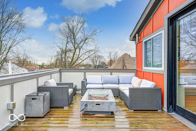 wooden terrace featuring an outdoor living space with a fire pit